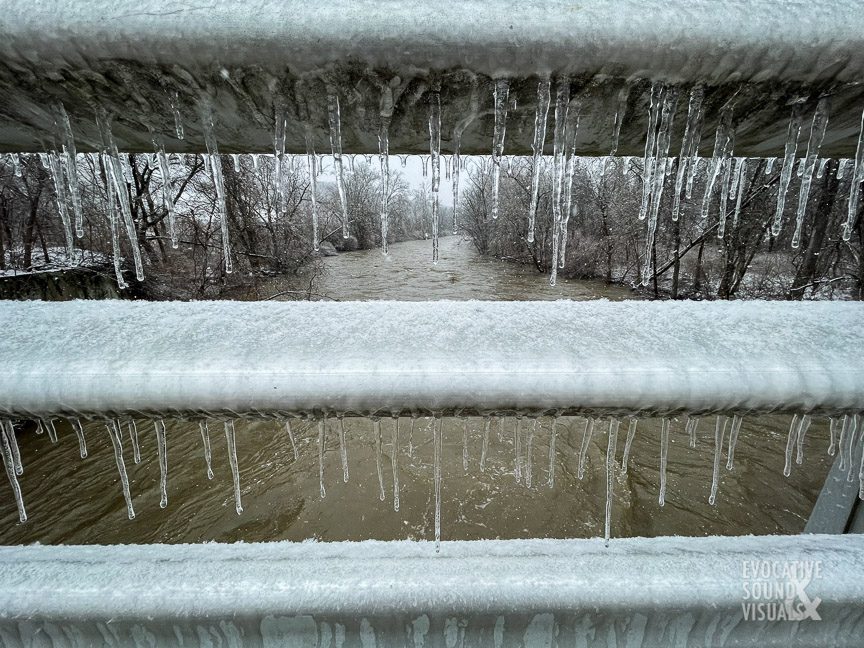 Icicles form along a bridge that spans a swollen Cuyahoga River in Cuyahoga Valley National Park in Boston, Ohio on February 25, 2022. Photo by Richard Alan Hannon