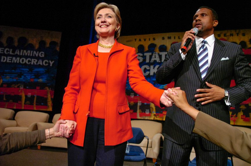 Democratic presidential hopeful Sen. Hillary Clinton (D-NY) holds hands with members of the crowd while television talk show host Tavis Smiley speaks at the "State Of The Black Union" symposium at the Ernest E. Morial Convention Center February 23, 2008 in New Orleans, Louisiana. Clinton earlier today heatedly accused Sen. Barack Obama (D-IL) of misrepresenting to voters her healthcare and NAFTA positions. Photo by Richard Alan Hannon