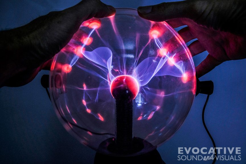 Recording the sound of brilliant blue tendrals reaching out from the center of an electrified plasma ball on Friday, December 18, 2020. Induction coil microphones, placed on opposite sides of the globe, are used to capture the sound. Photo by Richard Alan Hannon