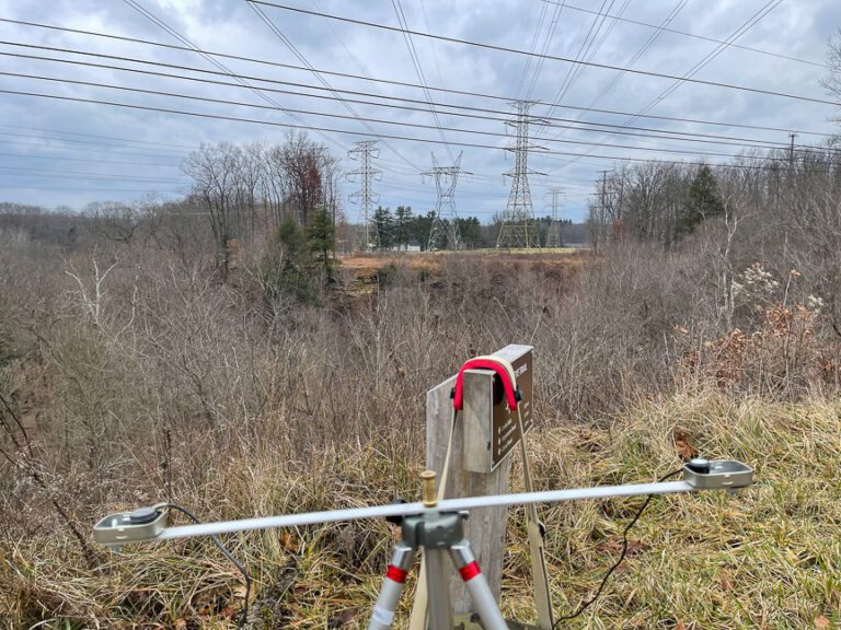 Capturing the sound of the electromagnetic field eminating from multiple 345kV overhead power transmission lines in Walton Hills, Ohio on Thursday, January 11, 2024. On August 14, 2003, approximate 120 feet northwest of this location, these lines, sagging by strain put upon them by power-hungry air conditioners and other appliances, flashed over to overgrown trees, thus contributing to a cascading power failure that shut down the electrcity grid for much of the northeastern United States and southeastern Canana. Photo by Richard Alan Hannon